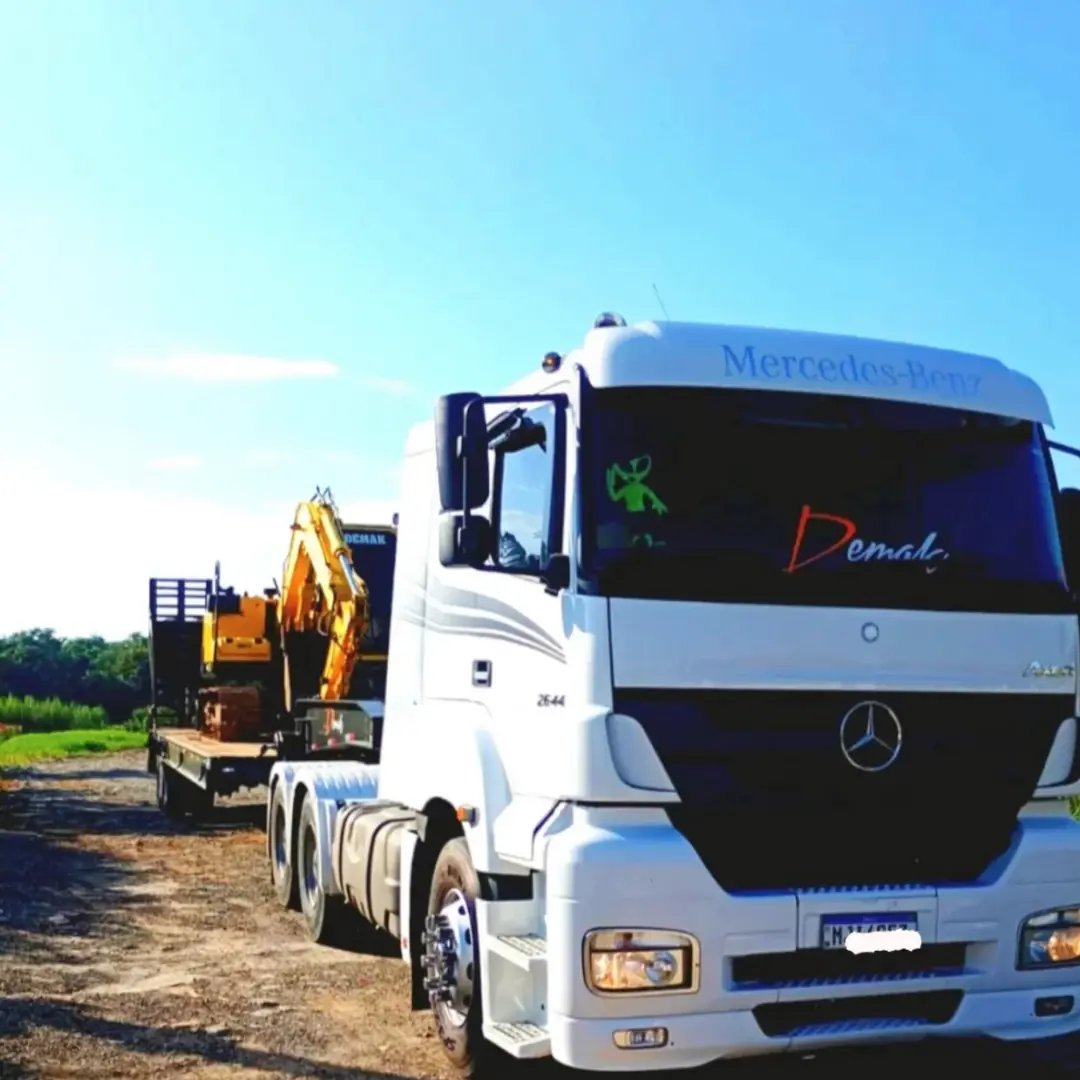 Caminhão prancha Mercedes-Benz Axor 2644 da Demak transportando escavadeira para obra